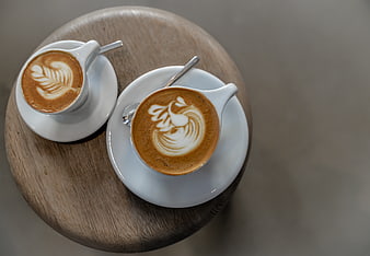 Top view of two latte art coffees on a wooden table