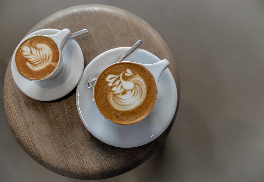 Top view of two latte art coffees on a wooden table