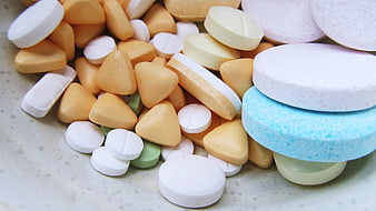 Assorted Colorful Pills and Tablets in a Bowl