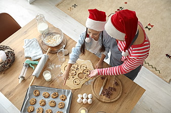 Mother and daughter baking Christmas cookies in kitchen