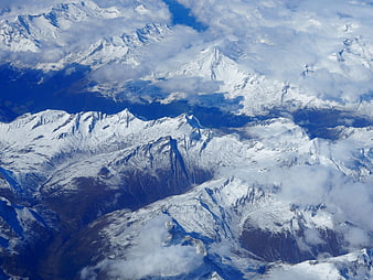 Aerial view of snow-capped mountain peaks with clouds