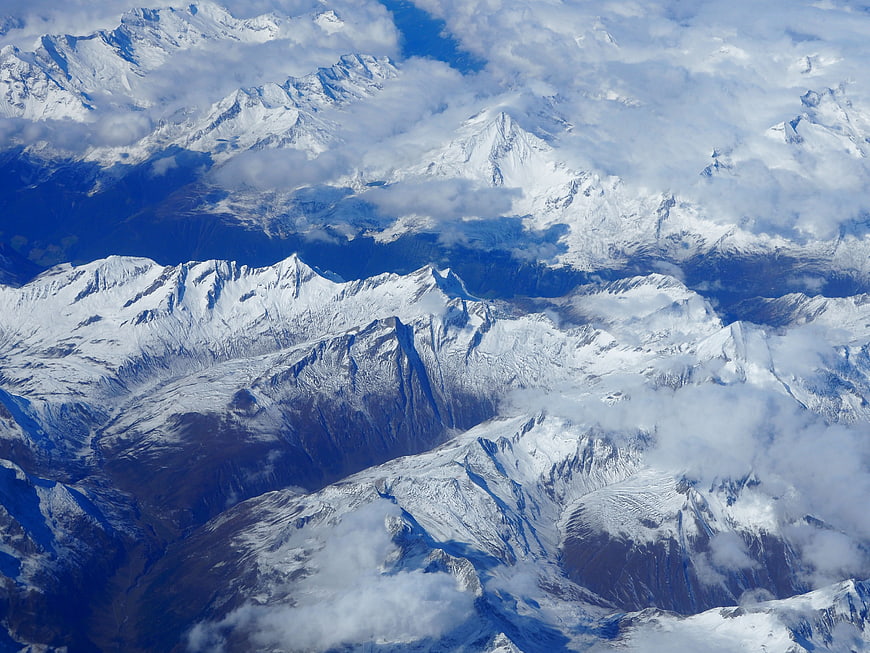 Aerial view of snow-capped mountain peaks with clouds
