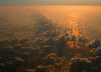Aerial View of Golden Sunset Clouds from Airplane Window