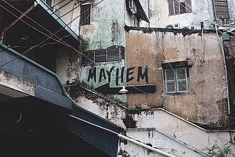 Weathered urban wall with MAYHEM graffiti and arrow