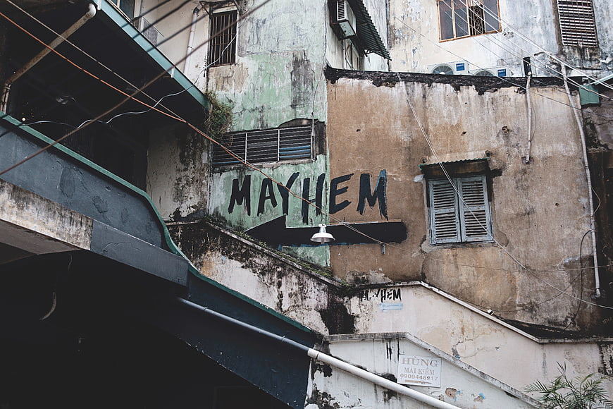 Weathered urban wall with MAYHEM graffiti and arrow
