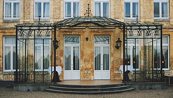 Elegant Chateau Entrance with Glass Canopy and Brick Facade