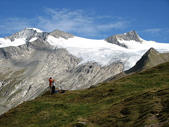 Hikers admiring snowy mountain peaks in the Alps