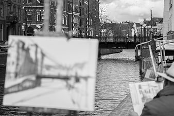 Artist painting canal bridge in black and white
