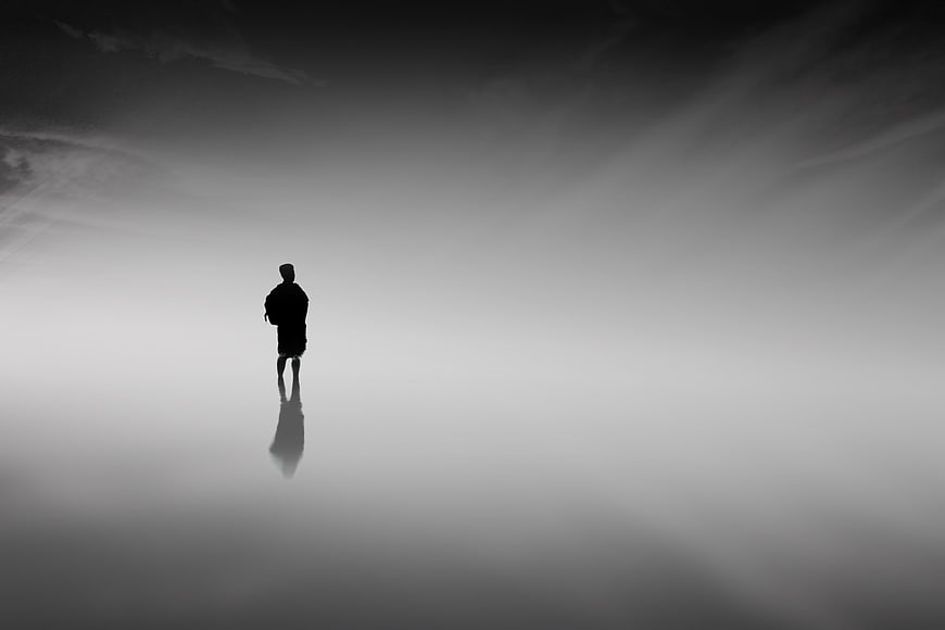Silhouette of Man Standing in Foggy Minimalist Landscape