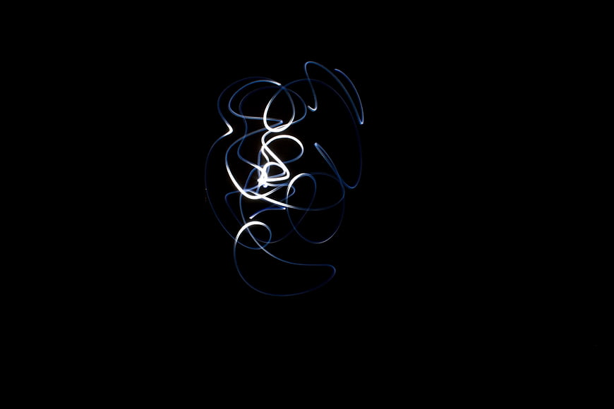 Abstract white and blue light painting swirl on black background