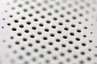 Close-up of white perforated surface with geometric pattern
