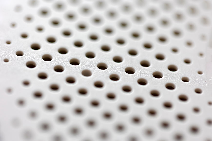 Close-up of white perforated surface with geometric pattern