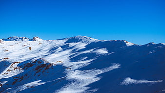Snow-Covered Mountain Peaks Under Clear Blue Sky