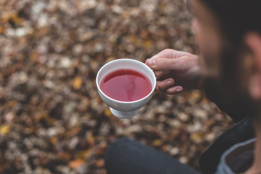 Man Holding White Cup of Red Tea in Autumn