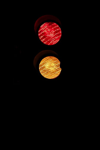 Close-up of red and yellow traffic lights at night