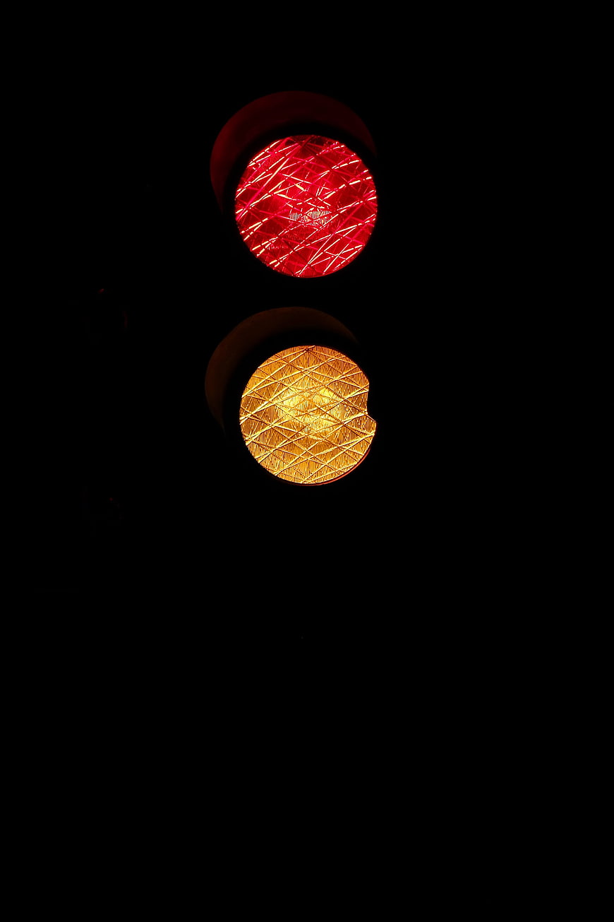 Close-up of red and yellow traffic lights at night