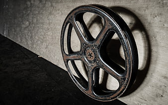 Vintage Film Reel Leaning Against Concrete Wall