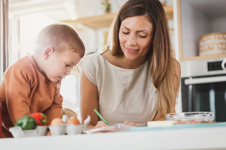 Mother and son cooking together in bright kitchen