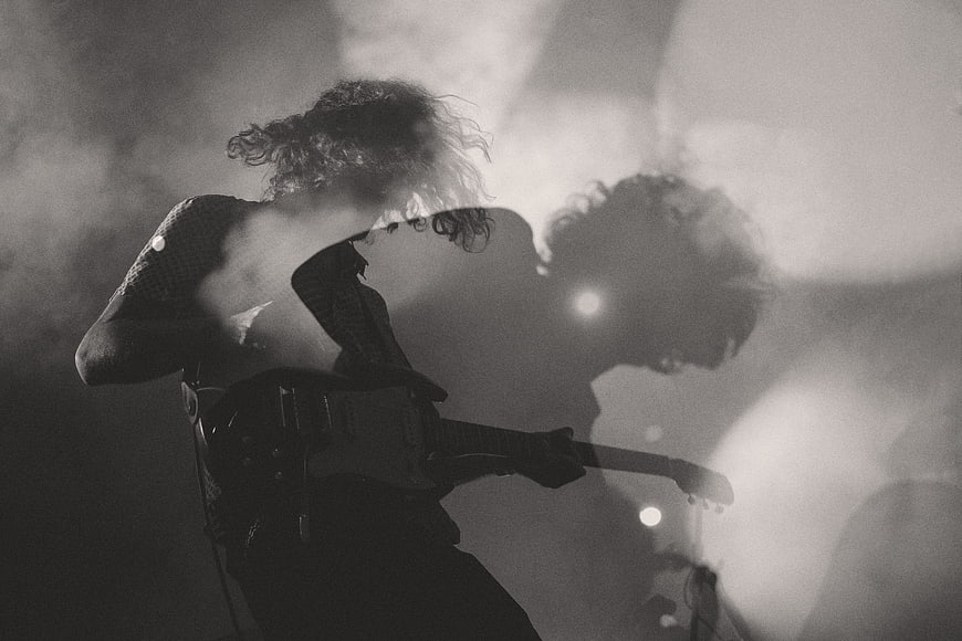 Rock guitarist performing on stage in black and white