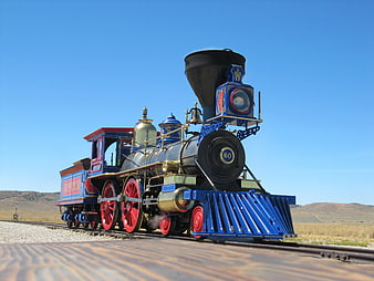 Vintage Blue and Red Steam Locomotive on Desert Railroad Tracks