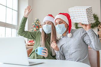 Couple in Santa Hats and Masks Video Calling with Gift