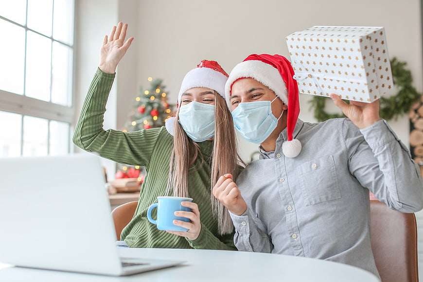 Couple in Santa Hats and Masks Video Calling with Gift