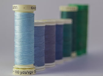 Colorful spools of sewing thread in a row
