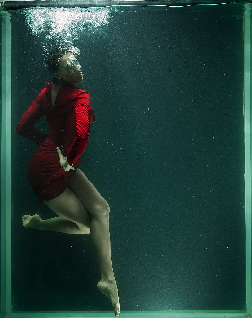 Underwater fashion portrait of a woman in a red dress