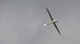 White Glider Soaring in Gray Overcast Sky