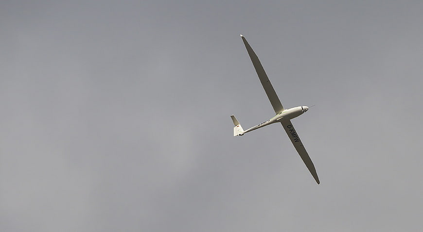 White Glider Soaring in Gray Overcast Sky