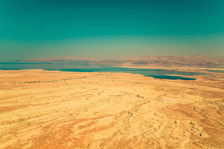 Aerial View of Desert Landscape with Turquoise Water and Mountains
