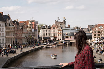Woman overlooking historic canal cityscape in Europe