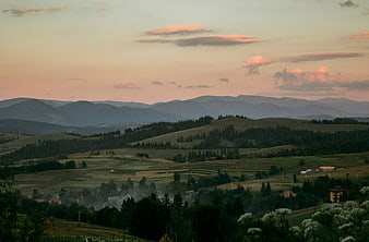 Rolling Hills and Mountains at Sunset with Pink Clouds