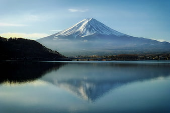 Snow-capped Mount Fuji reflected in calm lake water