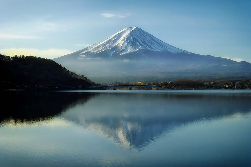 Snow-capped Mount Fuji reflected in calm lake water