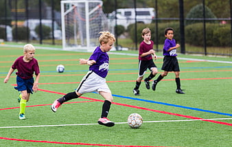 Young boys playing soccer on artificial turf field
