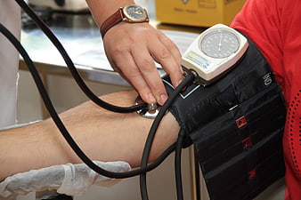 Doctor measuring blood pressure with manual sphygmomanometer