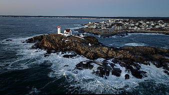 Aerial view of Nubble Light lighthouse on rocky island with crashing waves