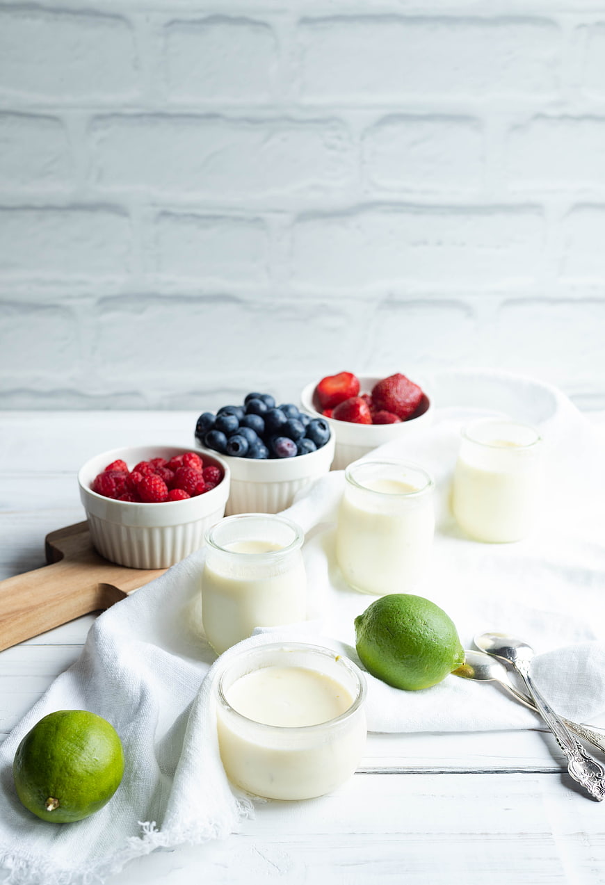 Homemade lime panna cotta with fresh berries and limes