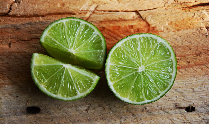 Fresh Cut Limes on Rustic Wooden Background