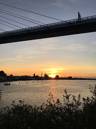 Sunset View Under Bridge Over Water With City Skyline