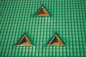 Green tiled roof with three triangular dormer windows