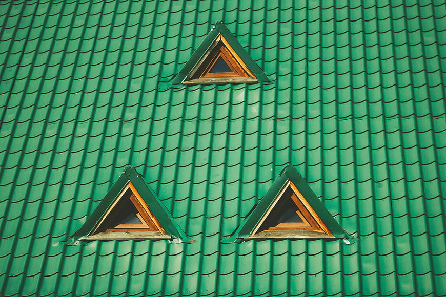 Green tiled roof with three triangular dormer windows
