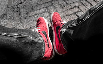 Red Nike Sneakers on Paved Ground