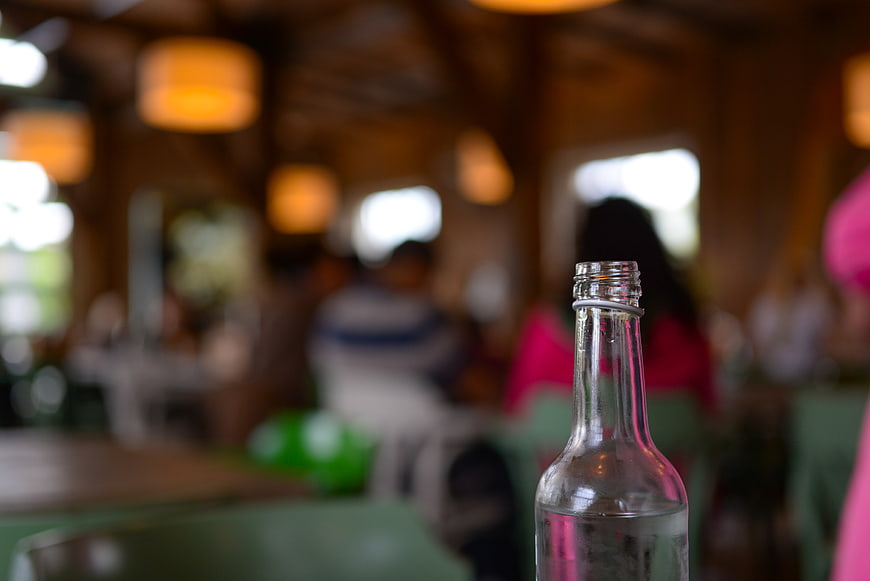 Glass water bottle in restaurant with bokeh background