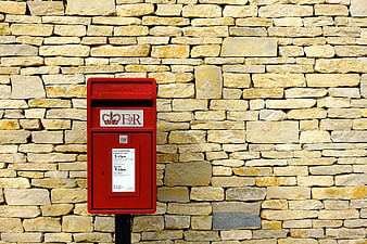 Red Royal Mail Post Box Against Stone Wall