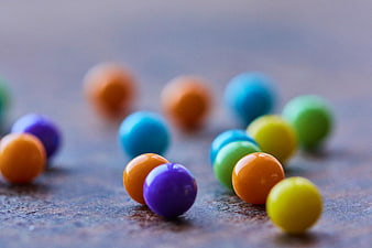 Colorful Round Candies Scattered on Textured Surface