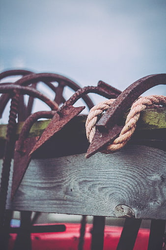 Rusty anchors and rope on wooden boat railing