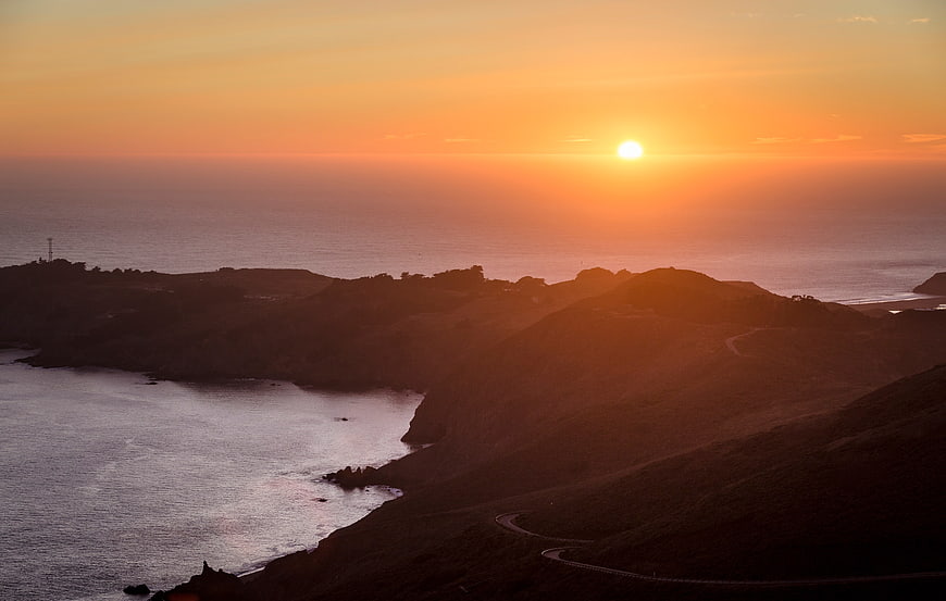 Golden sunset over coastal hills and winding road