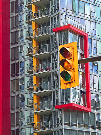 Yellow Traffic Light Against Modern Colorful Apartment Building